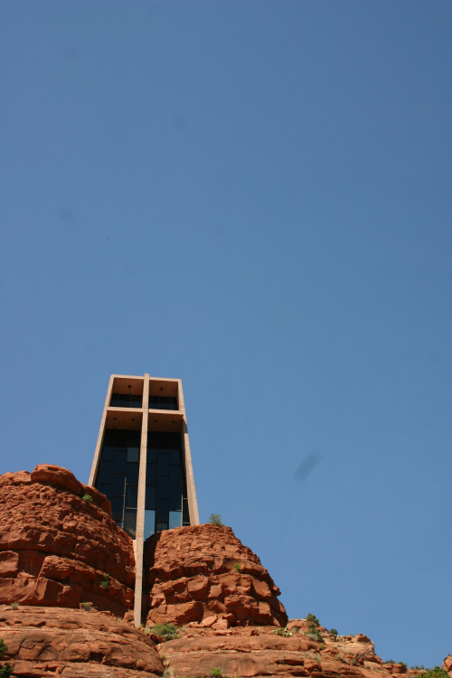 A church with the front of a large cross framed in glass